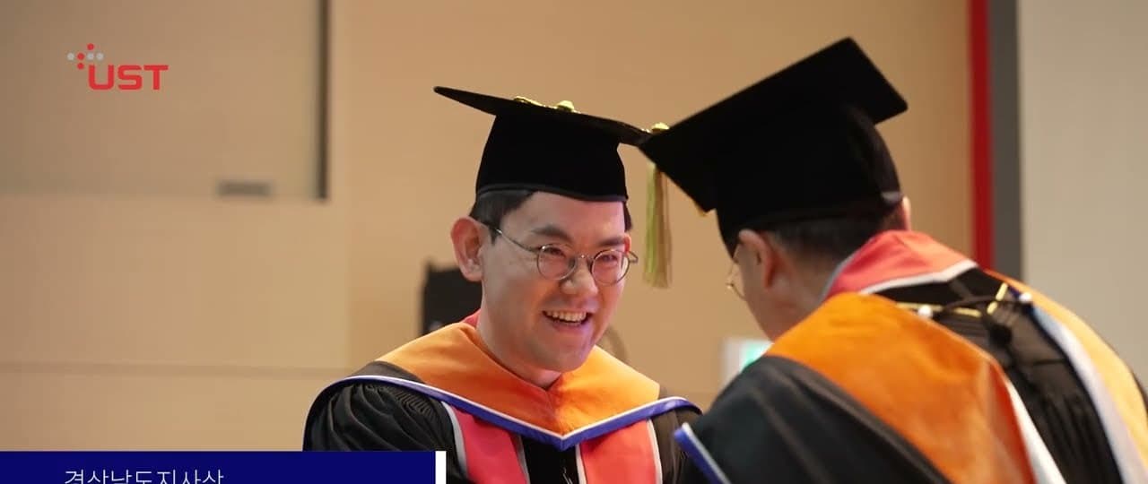 UST 학위수여식에서 졸업 가운을 입은 수상자와 시상자